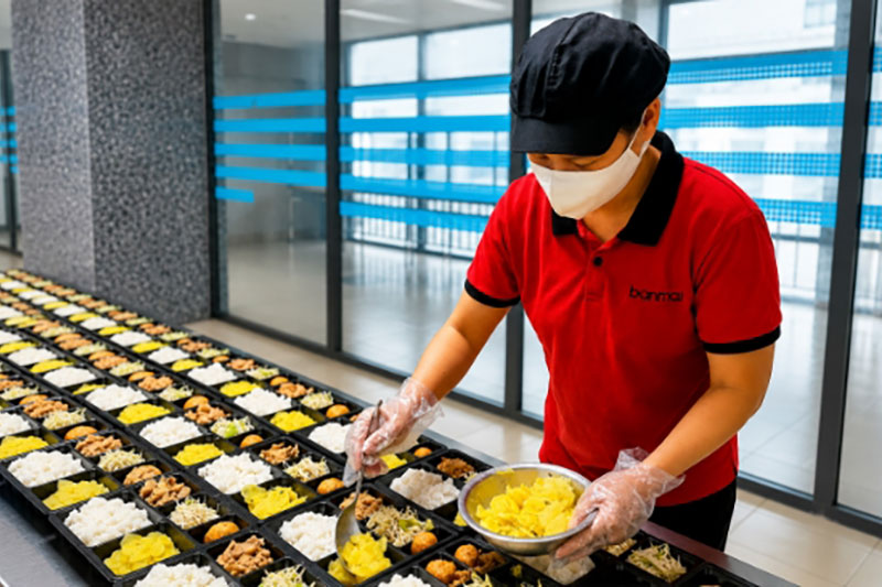 Đội ngũ Ban Mai chuẩn bị hàng trăm suất ăn mỗi ngày, đảm bảo chất lượng và đúng tiến độ phục vụ
